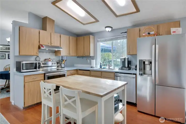 Kitchen has island with seating, and lots of stainless upgrades. There is a skylight that is functional - it cranks to open.
