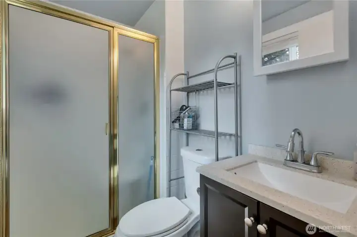 Master bath has a larger shower stall, plus toilet and sink with storage.