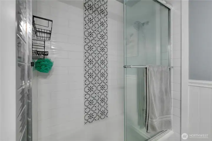 The tile details span into the bathtub (this has a tub & shower).