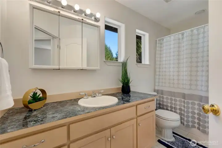 The upper-level full bathroom combines style and functionality, serving both family and guests with ease.