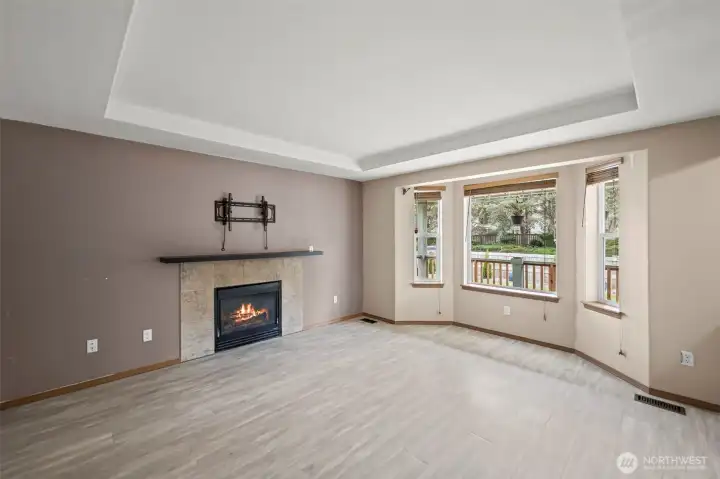 Open living room with lots of windows, fireplace, and wall mount for TV