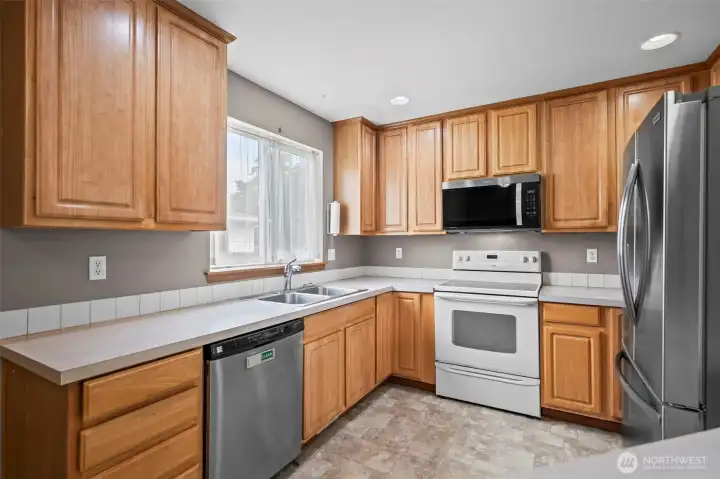 Kitchen with newer dishwasher, microwave, and fridge
