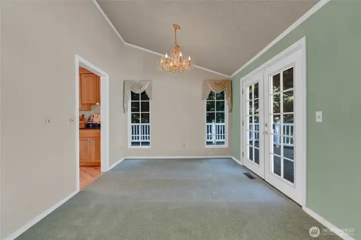 Unstaged dining room with crystal chandelier.