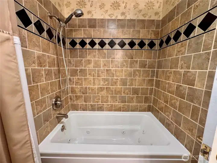 Pretty tiled shower with jetted tub.