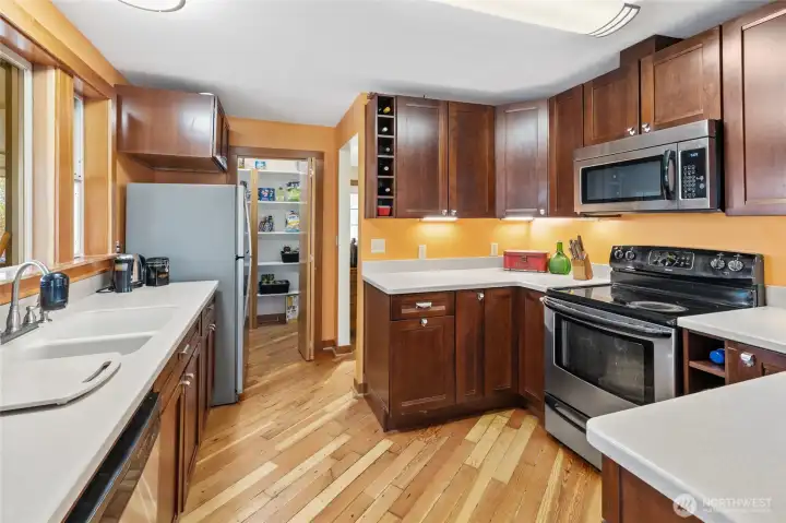 Kitchen features beautiful fir flooring, Corian countertops, a spacious walk-in pantry, and all appliances included.