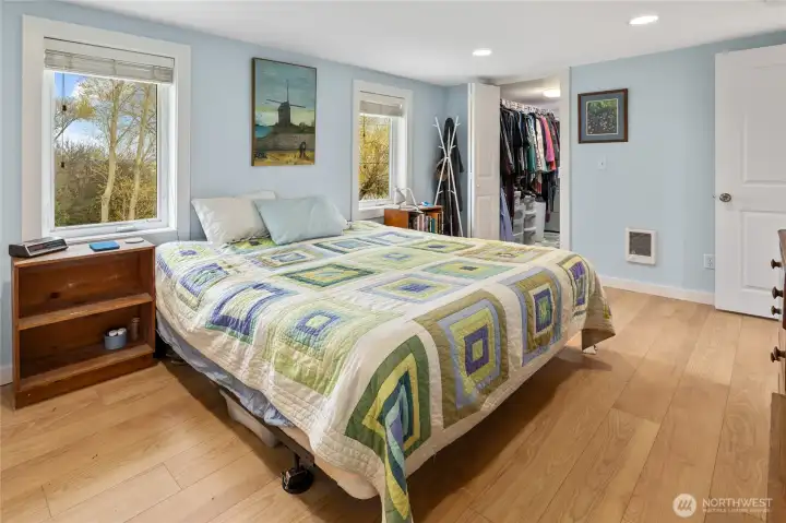 The primary bedroom features a large walk-in closet plus laundry area, new looring, and beautiful views of Coleman Creek.