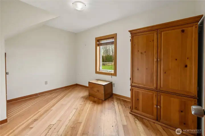 Bedroom #3 is located downstairs next to the full bath, featuring fir flooring, a closet under the stairs, and extra storage space.