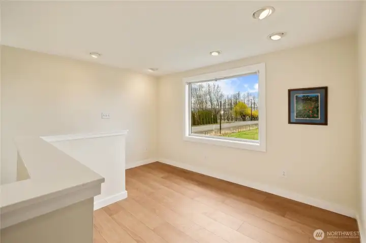 At the top of the stairs, a spacious landing area perfect for a cozy seating nook, workout space, or playroom, all with stunning views of the Stuart Mountains.