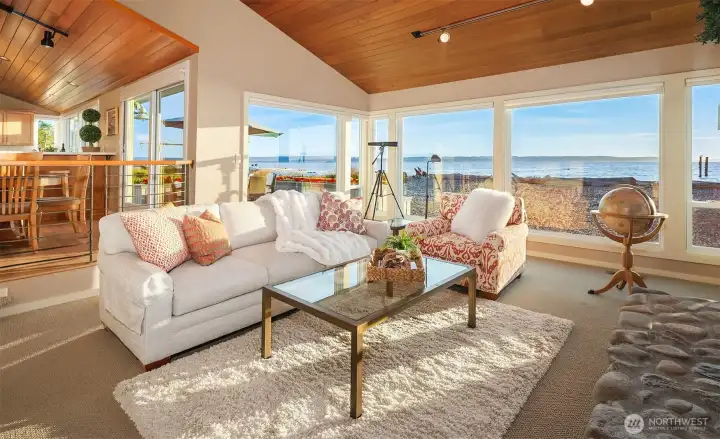 Step down Living room area off kitchen/dining area with wall of windows framing sweeping water views. Step down Living room area off kitchen/dining area with wall of windows framing sweeping water views.