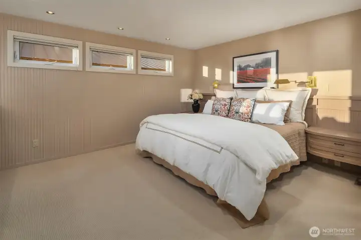 Primary bedroom with upper windows for privacy allowing abundant natural light. Primary bedroom with upper windows for privacy allowing abundant natural light.