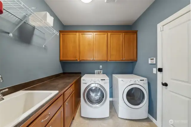 Laundry room has everything you should need- countertop for folding, cabinets to store cleaning products & deep sink for those things you just don't want to put in the washer. Located just off the garage & kitchen.