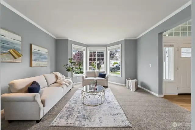 Soothing blue/gray color, white crown molding & bay window allow for light to flood this room.