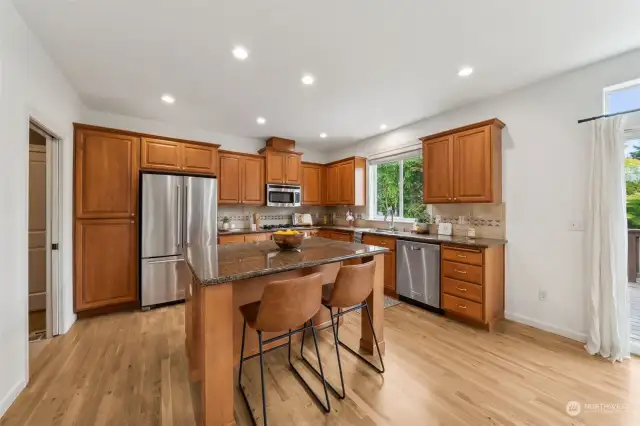 Well equipped kitchen with stainless steel appliances, gas range, full tile backsplash & breakfast bar for two!