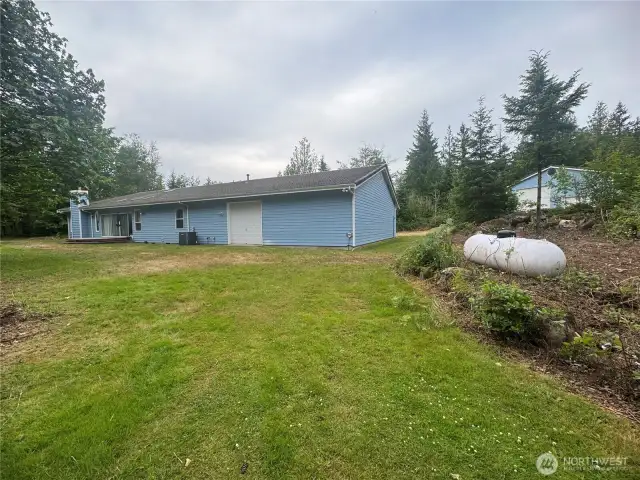 view of the back of the house. Back deck & drive through garage door.