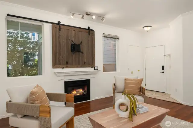 A cozy fireplace complements the room; the sliding barn door offers hidden storage behind.