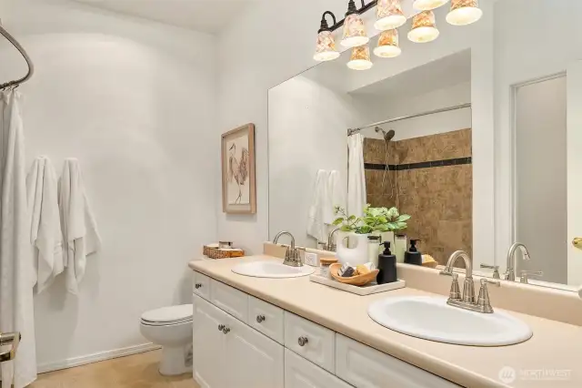 A double vanity is well appointed. The walk-in closet is offered to the left.