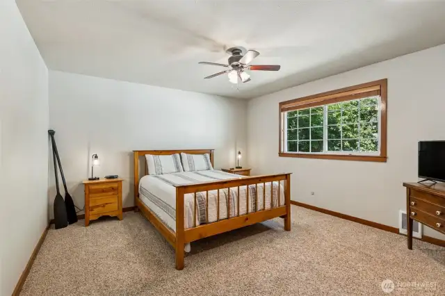 Large primary bedroom has a ceiling fan and large closet.