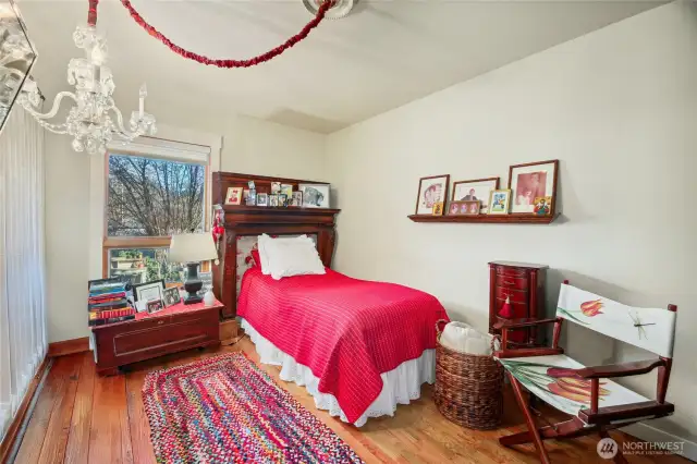 Bedroom #3 – South side of house  Views of side garden patio  Wall of built-in cabinets with shelves, pull-out drawers and display cubbies  Beautiful hardwood floors / Closet  Goes with Seller:  Antique footed wood mantle goes with Seller