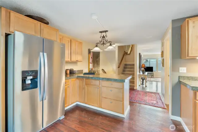 Kitchen with new appliances, looking out to the living room. You can also see the stairs leading up to the 3rd floor.