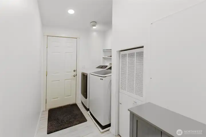 Laundry room with storage.  Door leads to attached 2 car garage and additional shop.