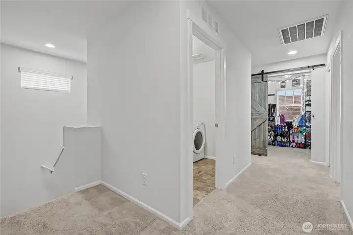 As you head upstairs, you will find the hallways are nice and roomy, your utility room on your left and straight ahead is the bonus room with barn door.