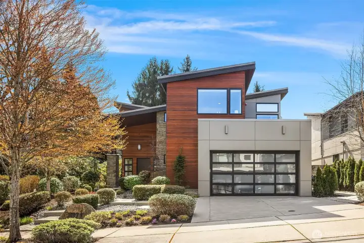 Striking modern exterior with clean lines, warm wood accents, and thoughtfully curated landscaping.