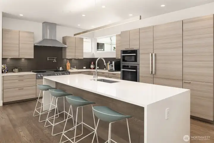 Chef’s kitchen with clean-lined cabinetry, oversized island, and seamless integration into the main living and entertaining spaces.