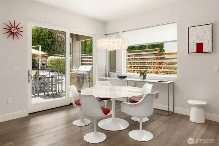 Light-filled dining space with seamless connection to the outdoors—anchored by iconic mid-century forms and effortless access to a private patio for everyday dining and entertaining.