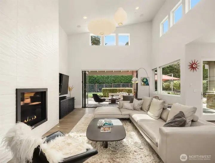 Soaring ceilings and a dramatic great room anchored by a sleek fireplace, opening seamlessly to the covered terrace beyond.