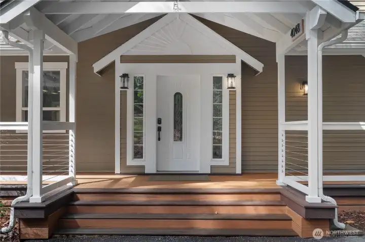 Welcoming front entry features updated decking and a spacious covered porch.