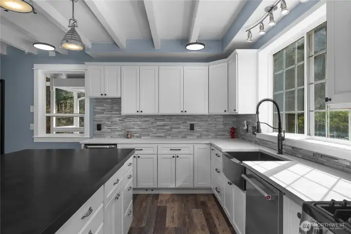 Stylish kitchen finishes include shaker cabinetry, solid-surface concrete counters, and tile backsplash.