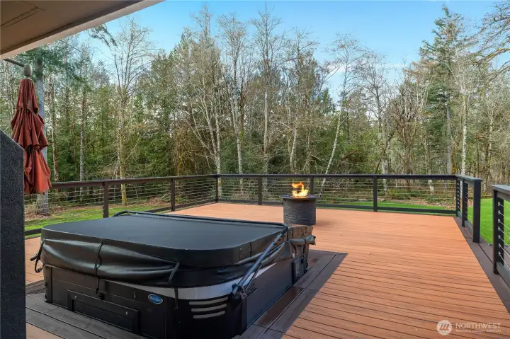 Expansive modern lookdeck with hot tub and new firepit (plumbed to the propane tank) overlooks the private wooded setting and includes space to unwind.