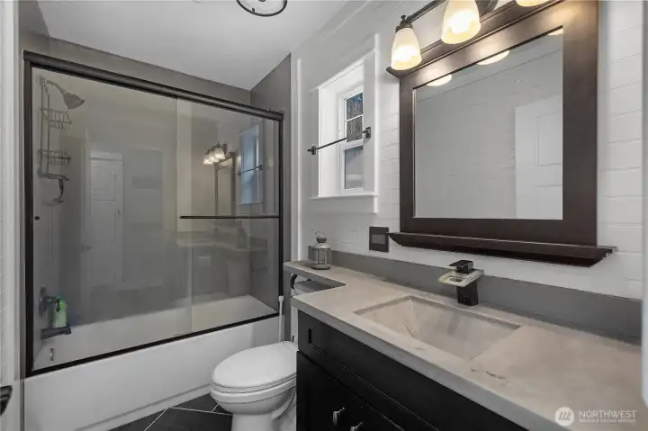 Updated bath features clean finishes and a modern vanity.