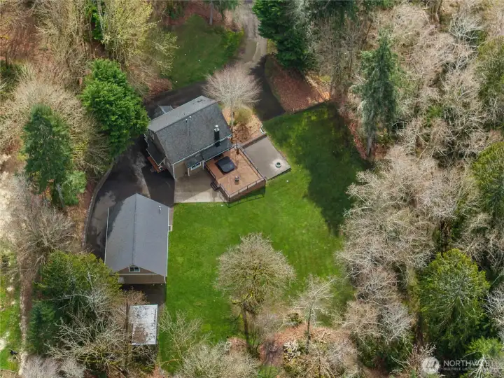 Overhead view highlights the home, detached shop, deck, and open yard space.