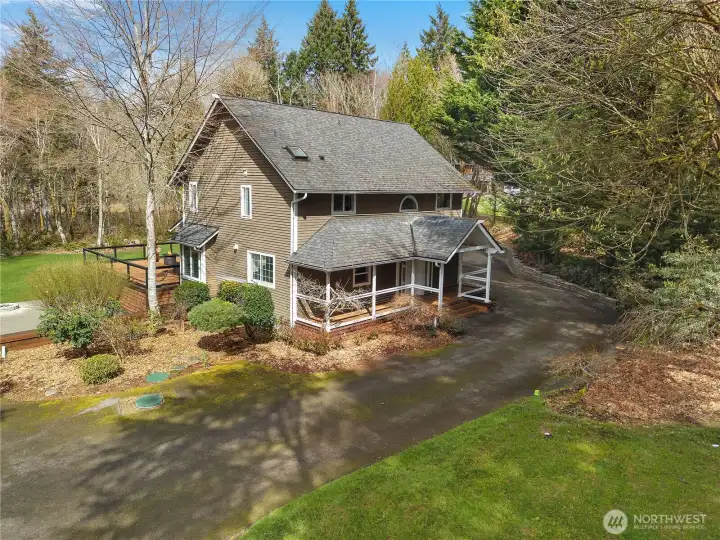 Aerial view highlights the home’s private approach and attractive setting among the trees.