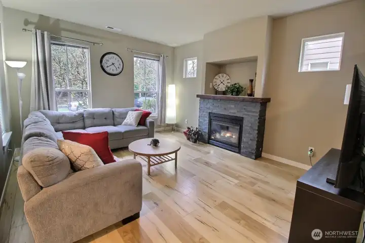 Living room with high ceilings, tall windows & gas fireplace.