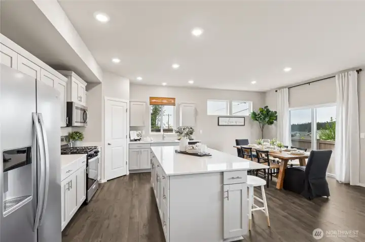 The kitchen offers soft close cabinet doors, solid quartz countertops, under mount sink and corner pantry. Photos are for representational purposes only.  Colors and finishes may vary. Refrigerator is a builder option.