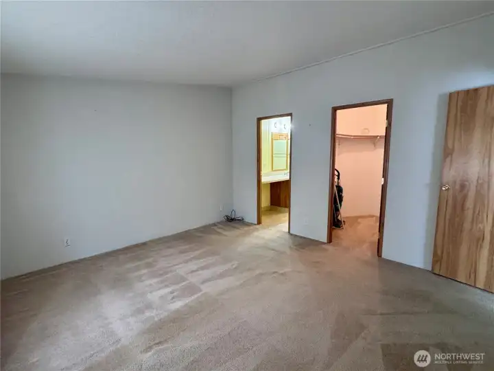 Primary bedroom with attached bathroom and walk in closet