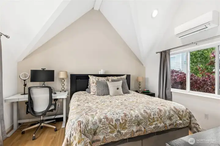 Vaulted ceilings in the primary bedroom and note the air conditioning along a with large window for lot and fresh air. Vaulted ceilings in the primary bedroom and note the air conditioning along a with large window for lot and fresh air.