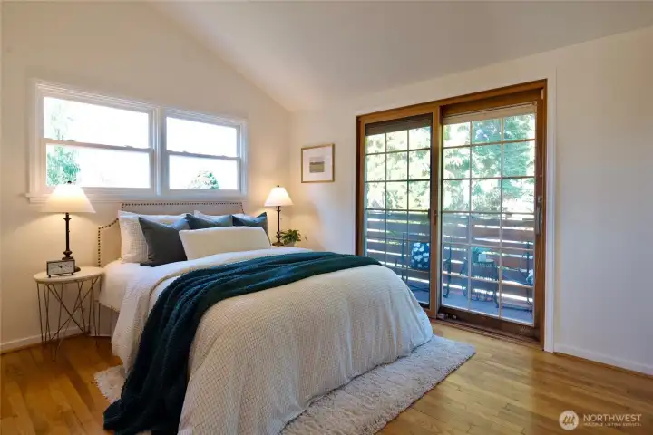 Vaulted ceilings, hardwood floors, and private deck access give the primary bedroom a bright, peaceful feel — with treetop views and cool evening breezes for easy sleeping.