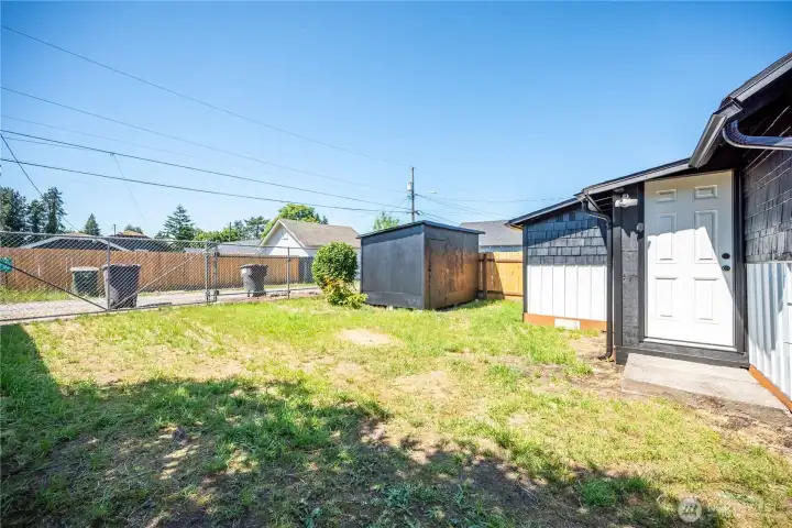 Fully fenced backyard featuring a 10' x 12' storage shed.