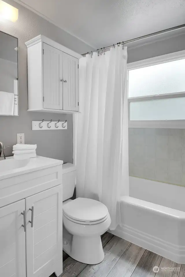 Remodeled full bath with LPV flooring, great light and updated vanity and cabinets.