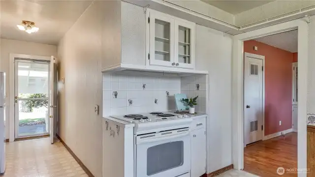 Kitchen Stove, View To Utility Closet Off The Dining Room W/ Furnace And Hot Water Heater