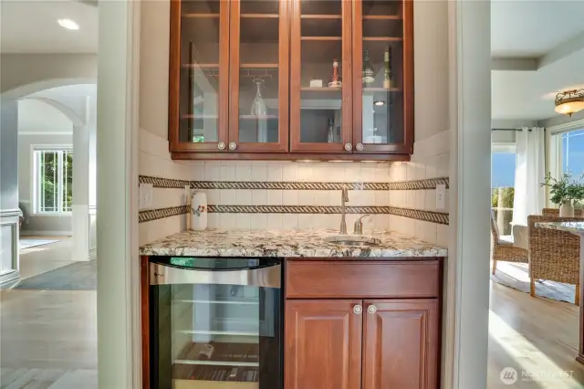 Butler's pantry with wine fridge, sink & glass door cabinets above is between the kitchen & dining room.