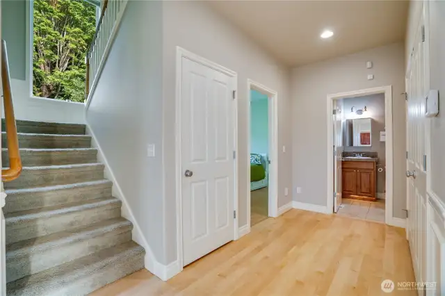 Main floor hallway with staircase to upper floor, nice width with large window for light.  Bedroom to the left, full bath that serves the main floor, double door closet to the right.