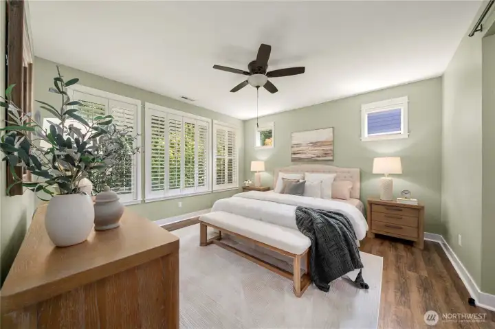 Generous primary bedroom with Plantation shutters overlooking the beautiful greenspace.