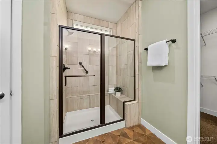 Tiled shower with convenient bench and niche.