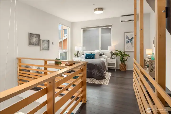 The airy primary suite offers a serene retreat with oversized windows, modern finishes, and an open loft-like design that fills the space with natural light.