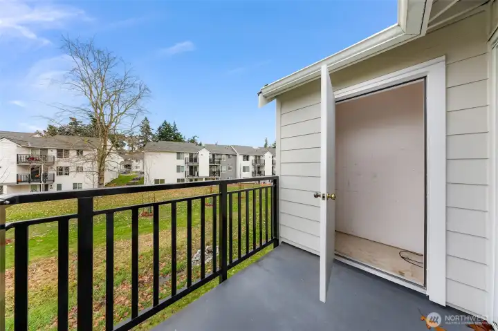 Balcony with additional storage, view of the grounds and green space between buildings