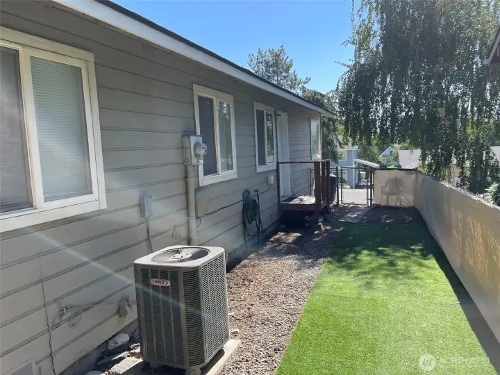 Unit A fenced side yard with low-maintenance turf.